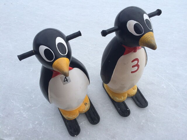 Pinguine helfen Kindern beim Schlittschuhlaufen